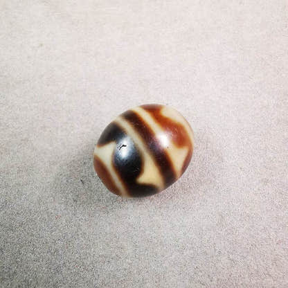 Tiger Tooth Dalo Dzi Bead - Tibetan dzi bead, close-up detail