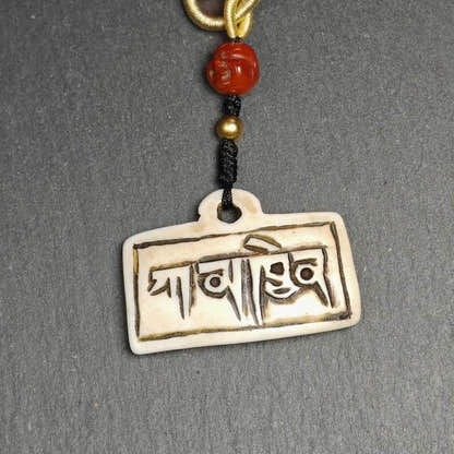 Amulet Badge with Tibetan Letters Karmapa - Tibetan Buddhist amulet, close-up detail