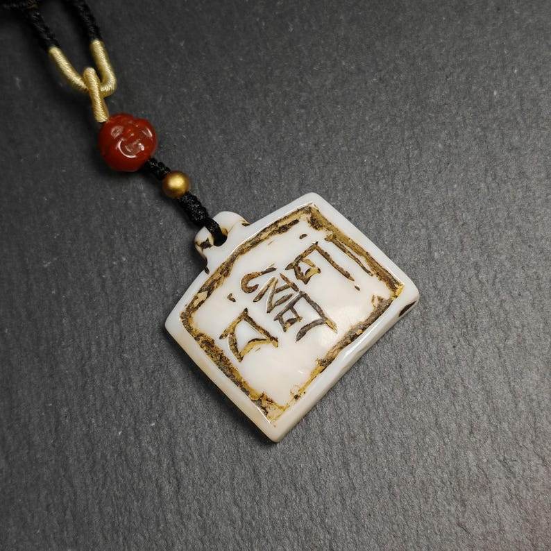 Amulet Badge with Tibetan Letters - Tibetan Buddhist amulet, close-up detail