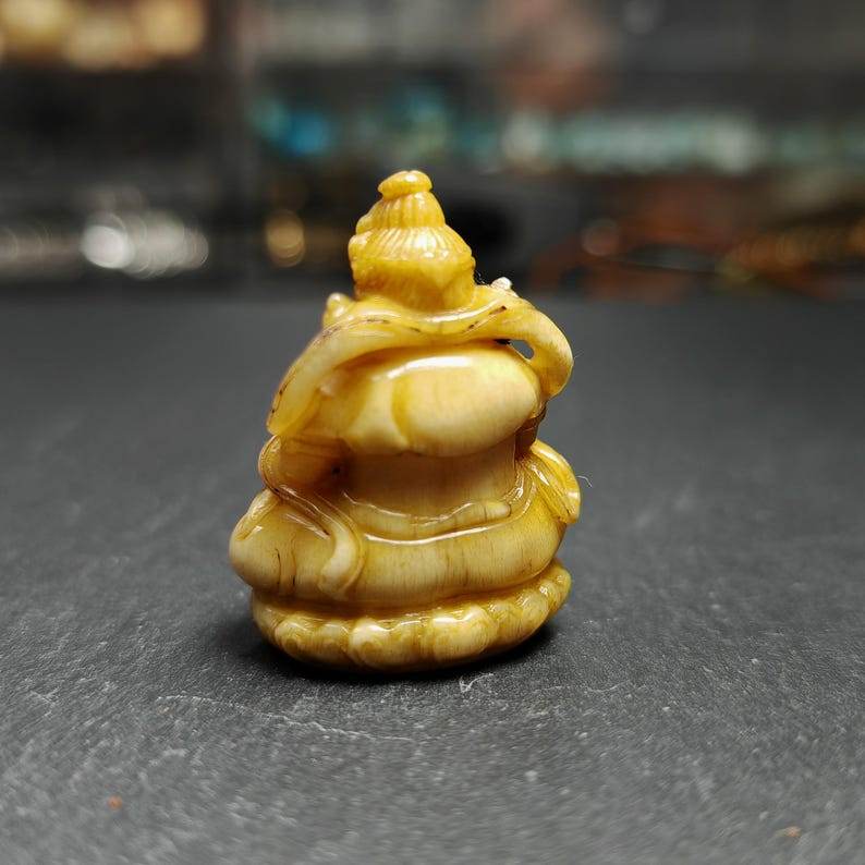 Buddha statue - Yellow Jambhala Dzambhala - Tibetan Buddhist statue, close-up detail