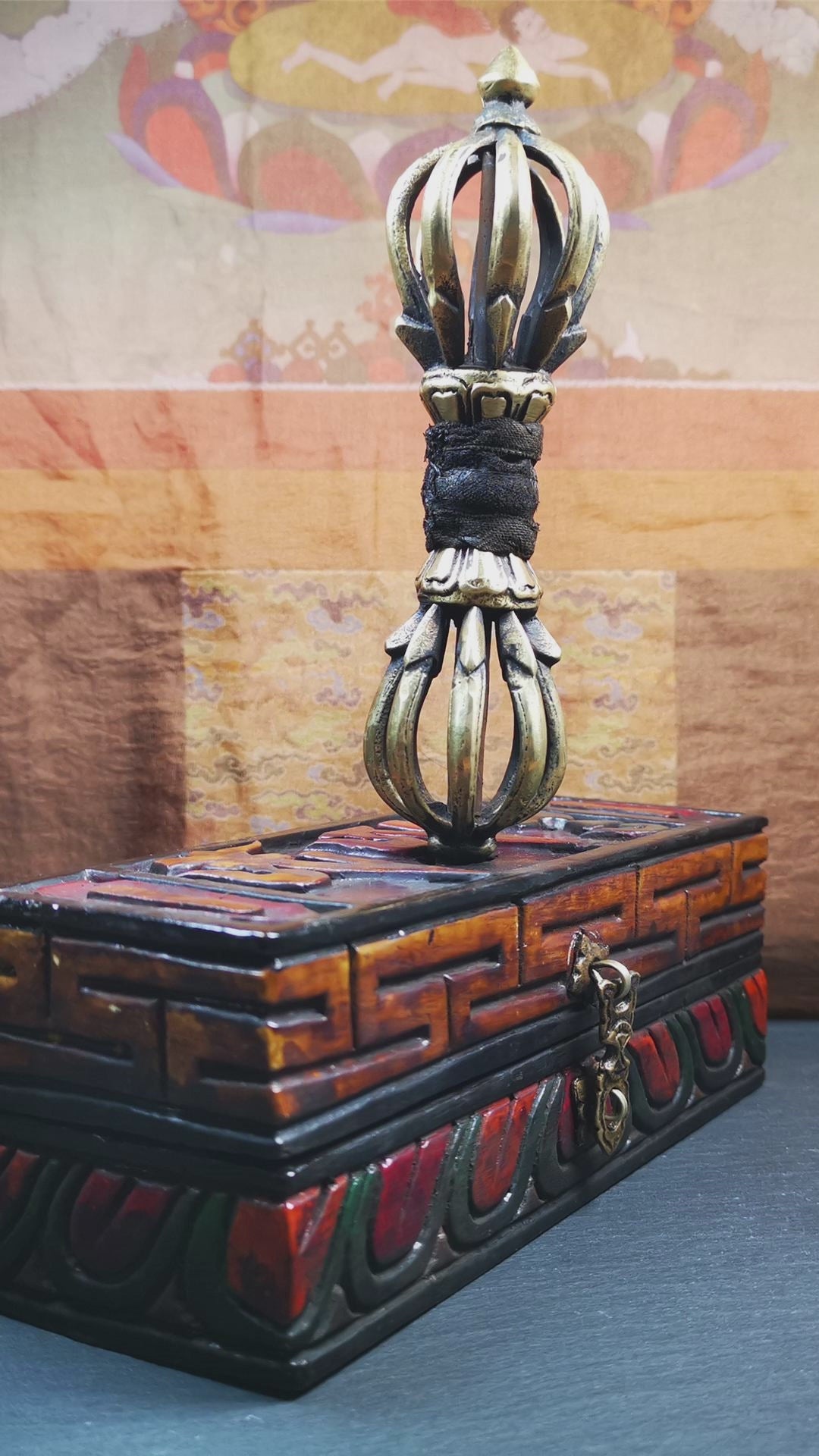 This vajra set was handmade in Nepal,using traditional techniques and materials. The Nine-pronged vajra is made of brass, and the outer box is made of wood,carved with the Tibetan letter of three karmas, or three modes of activities of word, thought , and deed,ཨཽ,ཨཱཿ,ཧཱུཾ The vajra can be inserted into the top of the box.