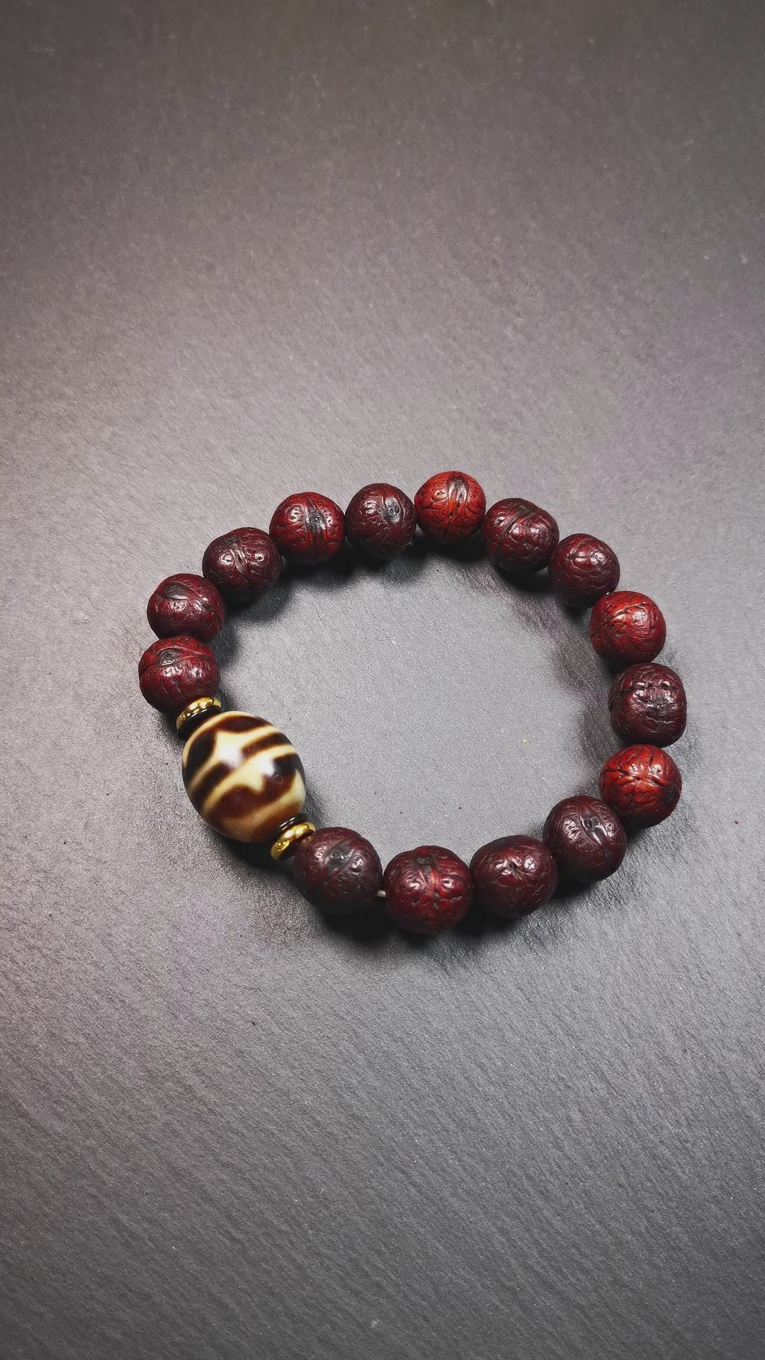 This unique Dalo Dzi bracelet combines the mysterious and unique qualities of the tiger tooth dalo dzi and 15 old bodhi seed beads,giving it a distinct feel.  It is brown in color and has a circumference of approximately 7 inches, suitable for most wrist sizes. 